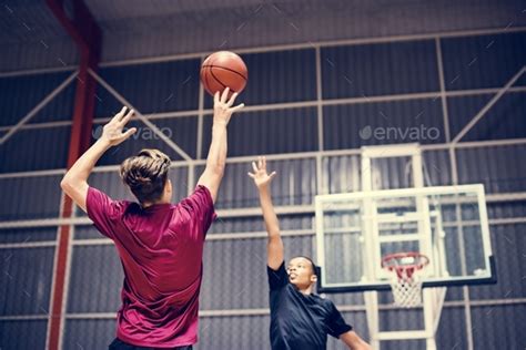 Two Teenage Boys Playing Basketball Together On The Court Stock Photo