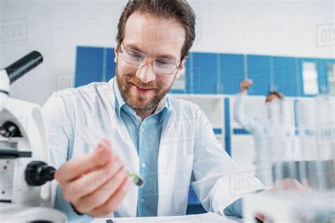 Selective Focus Of Smiling Scientist In White Coat And Eyeglasses