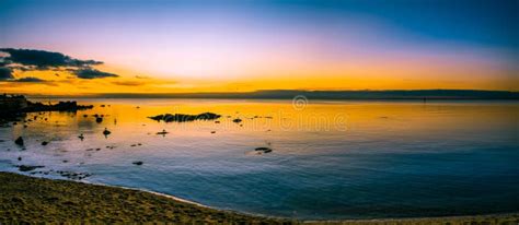 Panoramic Seascape Of Glowing Sunset Over Calm Ocean Bay Water Stock