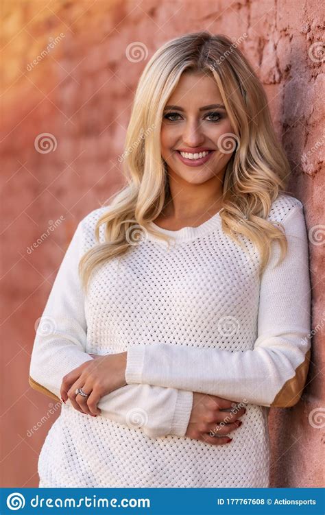 A Lovely Blonde Model Enjoys An Autumn Day Outdoors In A Small Town