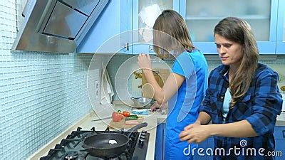Two Girls Lesbian Family Preparing Food In The Kitchen At Home Stock
