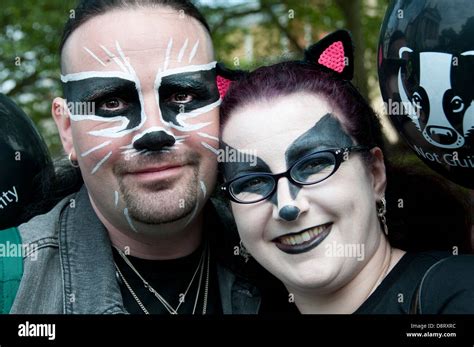 A Couple With Badger Face Paint Pose Holding A Balloon With A Picture