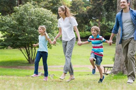 Padres E Hijos Caminando En El Parque Foto Premium