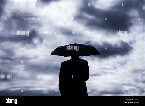 Businessman And Umbrella And Stormy Clouds Stock Photo Alamy