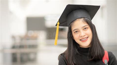 Young Happy Asian Woman University Graduate In Graduation Gown And Cap