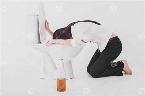 Mujer Borracha Que Vomita En Una Taza Del Inodoro Imagen De Archivo