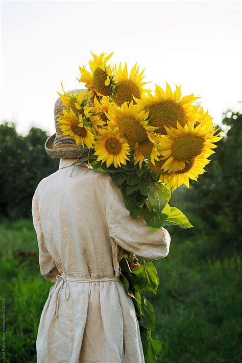 Girl Holding A Large Bouquet Of Sunflowers By Stocksy Contributor