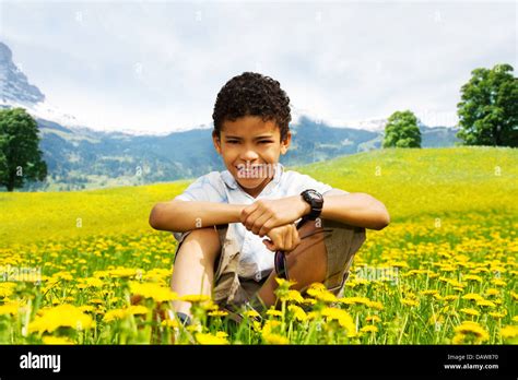Happy Smiling 10 Years Old Black Boy In The Yellow Dandelions Field