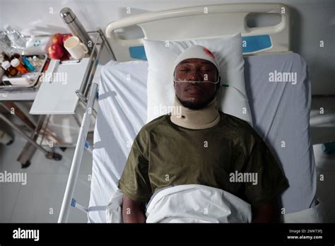 Soldier With Bleeding Head Injury Lying On Hospital Ward View From