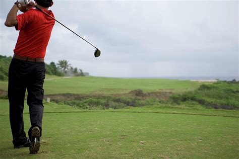 Man Swinging Golf Club Rear View Photograph By Flashfilm