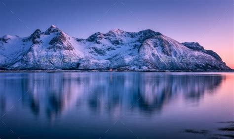 Snowy Mountains And Colorful Sky Reflected In Water At Sunset Snowy