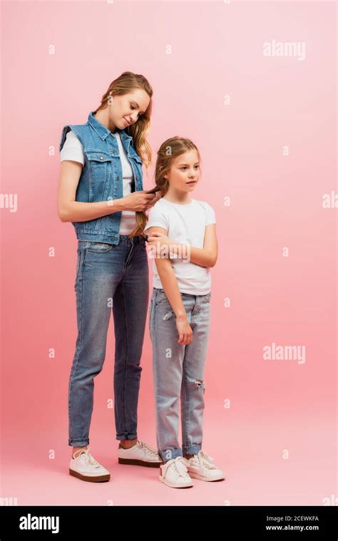 Full Length View Of Woman In Denim Clothes Braiding Hair Of Daughter