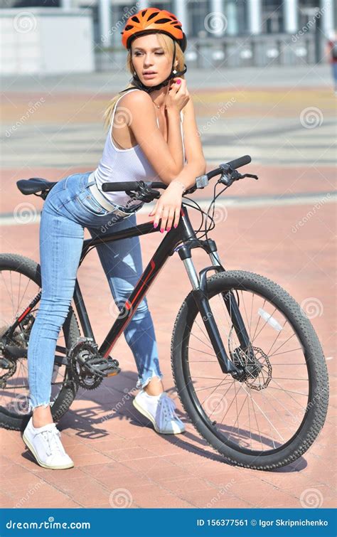 Fitness Pretty Blonde Girl With Big Boobs In White T Shirt Posing Outdoor On The Bicycle Imagen