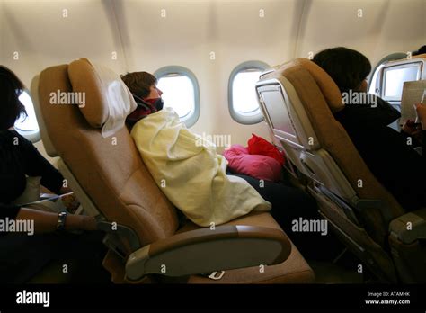 una mujer durmiendo en un pasajero del asiento reclinado en un vuelo de largo recorrido