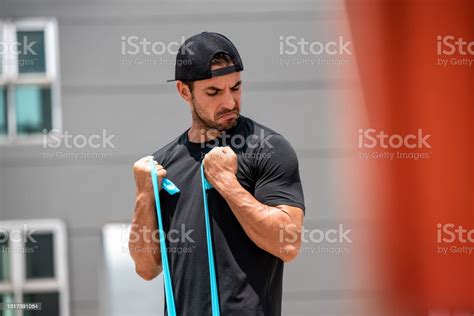 Fit Muscular Sports Man Doing Bicep Curl Exercise With Resistance Band