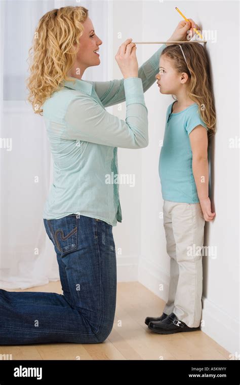 Mother Marking Daughter S Height On Wall Stock Photo Alamy