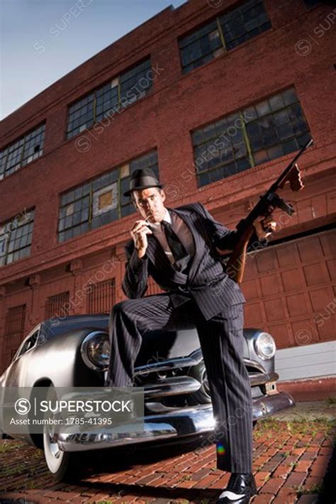 Gangster Holding Tommy Gun Leaning On Vintage Car Superstock