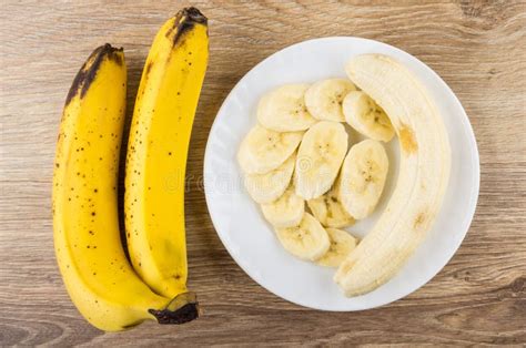Two Whole Yellow Bananas And Slices Of Bananas In Plate Stock Photo