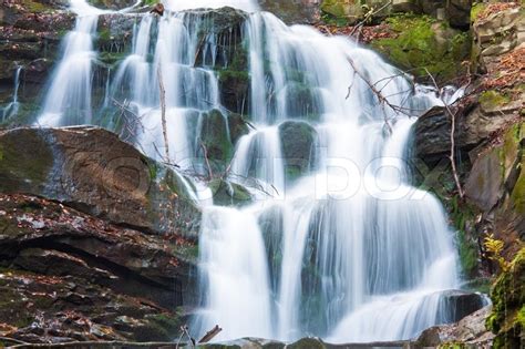 Waterfalls On Rocky Stream Running Through Autumn Mountain Forest