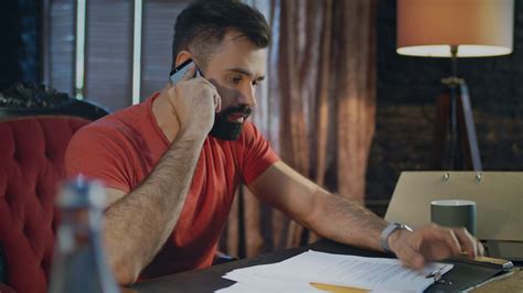 Young Business Man Hearing Bad News Talking On Phone In Home Office At