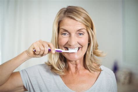Portrait Of Senior Woman Brushing Her Teeth In Bathroom Stock Image Image Of Female Home