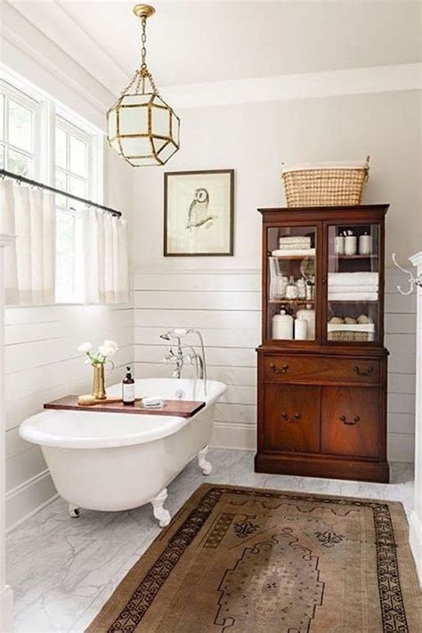 A White Bath Tub Sitting Next To A Wooden Cabinet In A Bathroom On Top