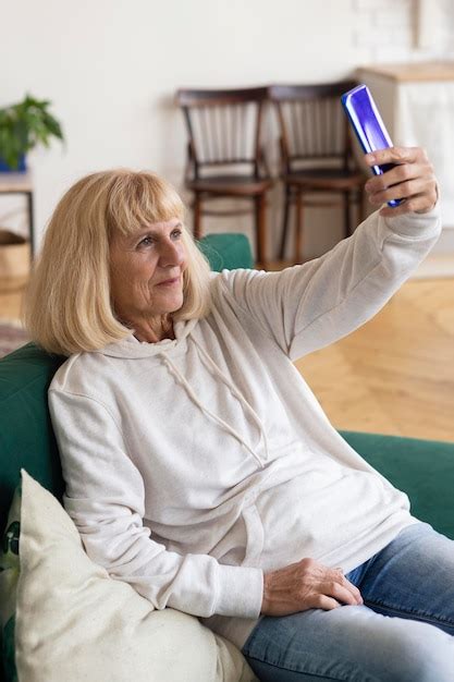 free photo older woman taking selfie with smartphone at home