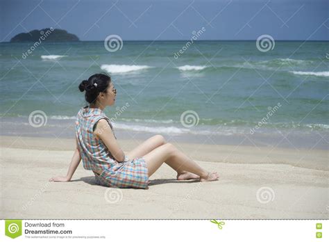 De Jonge Aziatische Vrouw Neemt Een Rust Op Het Strand Met Vage