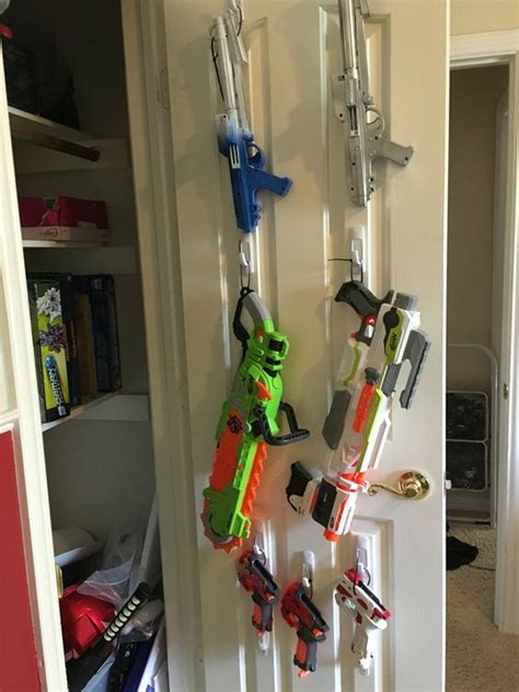 Was in a creative mood and built a nerf gun rack for the kids #nerf #nerfguns #guns #rifle #shotgun #diy #homedepot #weapons #artillery #toys #storage #organization #creative. Command hooks, super easy nerf gun storage. … | For Kids