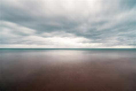 Overcast Sky Over Calm Endless Sea · Free Stock Photo
