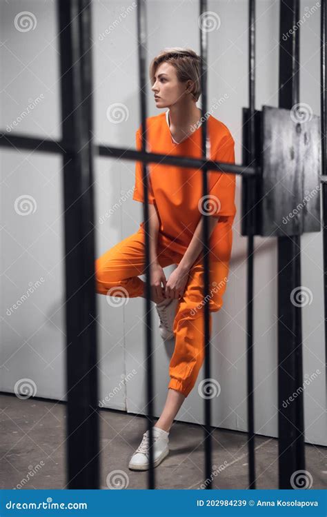 Blonde Inmate In An Asian Women`s General Security Prison Is Led Out Of Her Cell By A Uniformed