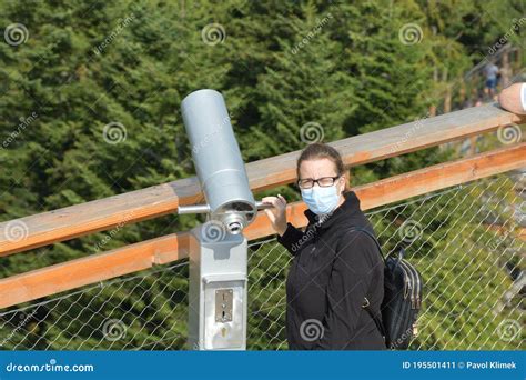 A Woman Looks Into The Binoculars At A Lookout Tower At The Surrounding