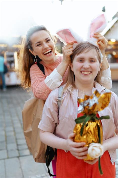 Portrait Of Smiling Modern Mother And Child At Fair In City Stock Photo