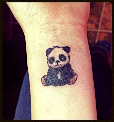 A Small Panda Bear Tattoo On The Wrist