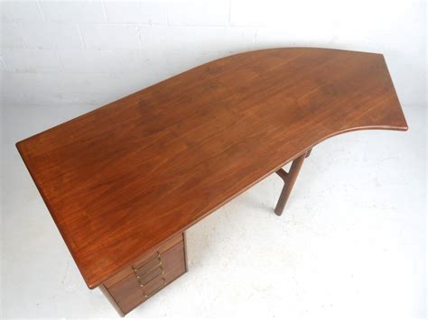 Each side has one straight piece, and the straight sides are joined by a curved work area. Unique Mid-Century Walnut Curved Executive Desk at 1stdibs