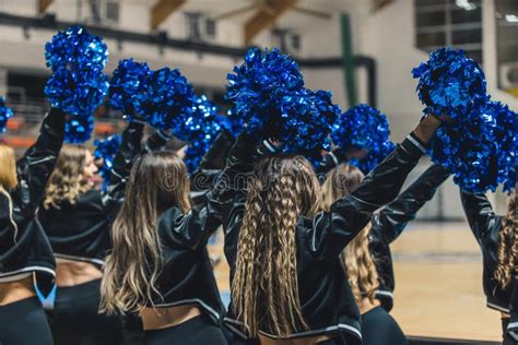 A Group Of Cheerleaders In Mid Performance Their Blue Pom Poms Waving In The Air Stock Image