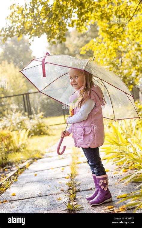 Slyly Smiling Girl Posing Under Umbrella In Park Stock Photo Alamy