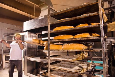 Bakery Worker Taking Out Freshly Baked Breads 12653090 Stock Photo At