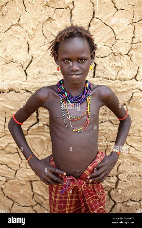 Portrait Of A Girl From Dassanech Tribe In Front Of A Cracked Walls Of A Traditional House Omo