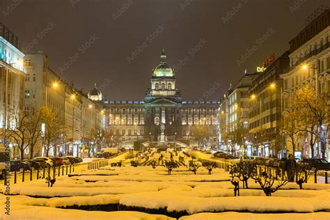チェコ 夜のプラハの国立博物館と雪の積もった街並み фотография Stock Adobe Stock
