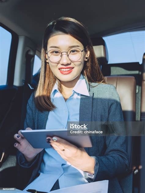 Young Businesswoman Using Tablet On Car Backseat Stock Photo Download