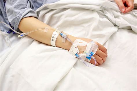 Patient With Iv Lines In Hospital Bed Stock Photos Pictures And Royalty