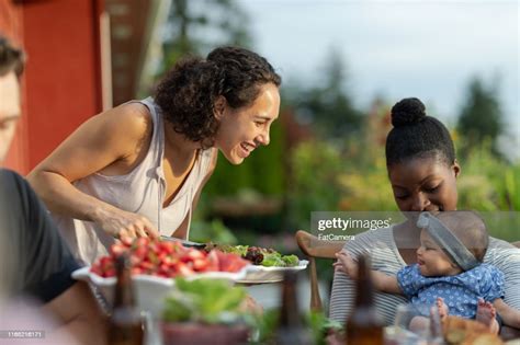 A Group Of Young Adult Friends Dining Al Fresco On A Patio High Res