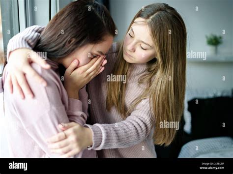 Teenage Girl Consoling Her Sad Friend On Her Bedroom Stock Photo Alamy