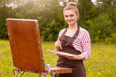 Artist Paints Picture In Open Air Holding Oil Paint Brush In Hand And