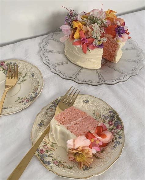 Two Pieces Of Cake On Plates With Flowers In The Middle And One Piece
