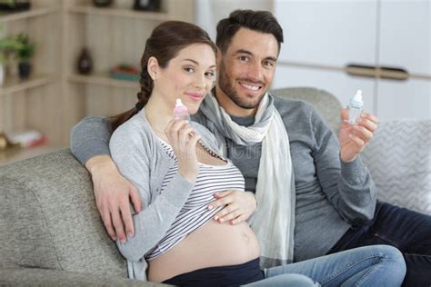 Pregnant Couple Holding Blue And Pink Bottles Stock Image Image Of Sitting Relaxed 254430255