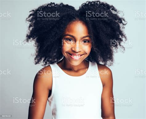 Cute Young African Girl Smiling Confidently Against A Gray Background