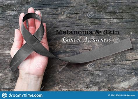 Melanoma And Skin Cancer Black Awareness Ribbon On Human Helping Hand