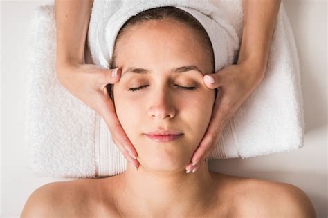 Belle Jeune Femme Recevant Un Massage Du Visage Avec Les Yeux Fermés Dans Un Salon Spa Photo